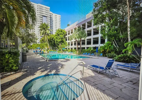 a view of a swimming pool with a lawn chairs and plants