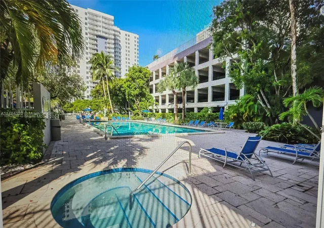 a view of a swimming pool with a lawn chairs and plants