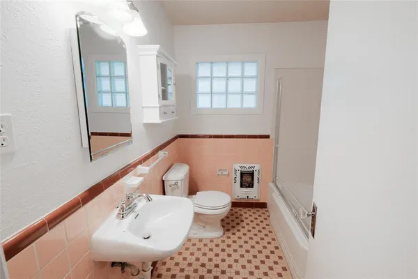 a bathroom with a sink toilet and mirror