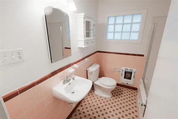 a bathroom with a sink a toilet and a mirror