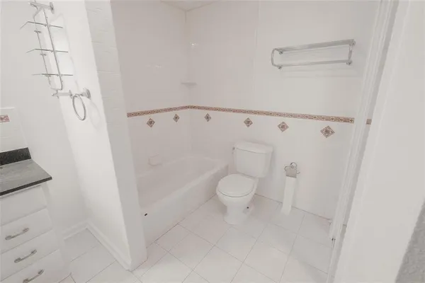 a white toilet sitting next to a shower