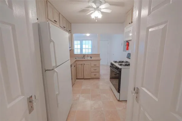 a kitchen with white cabinets and white appliances