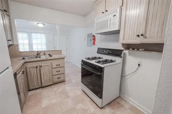a kitchen with granite countertop a sink stove and cabinets