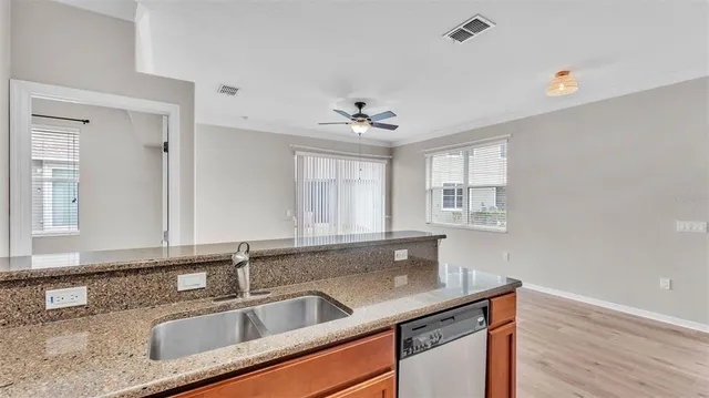 a view of a kitchen with a sink and dishwasher a refrigerator with wooden floor