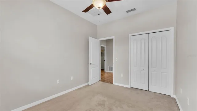 an empty room with a window and a ceiling fan
