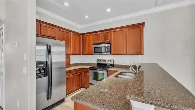 a kitchen with stainless steel appliances granite countertop a refrigerator a stove top oven a sink and dishwasher