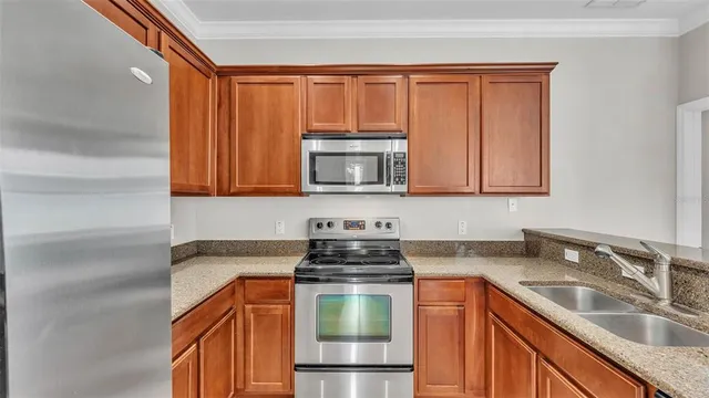 a kitchen with kitchen island granite countertop a sink stainless steel appliances and cabinets