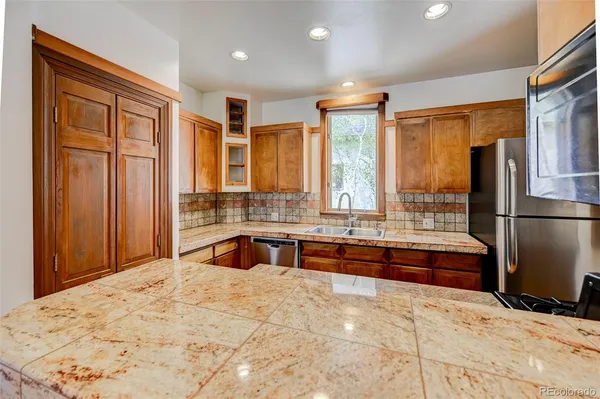 a large kitchen with kitchen island granite countertop a refrigerator oven stove and a sink