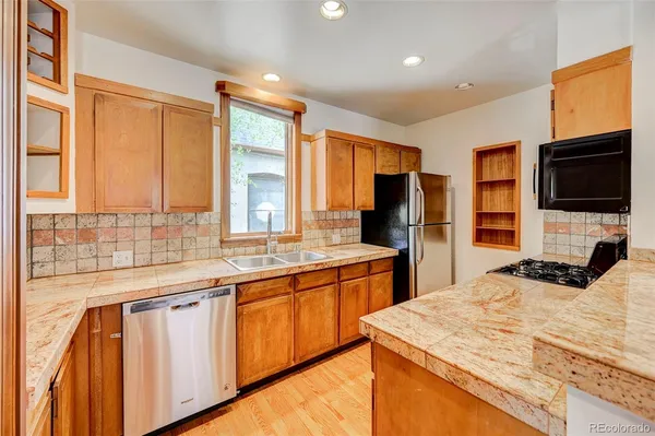 a kitchen with stainless steel appliances granite countertop a sink a stove and refrigerator