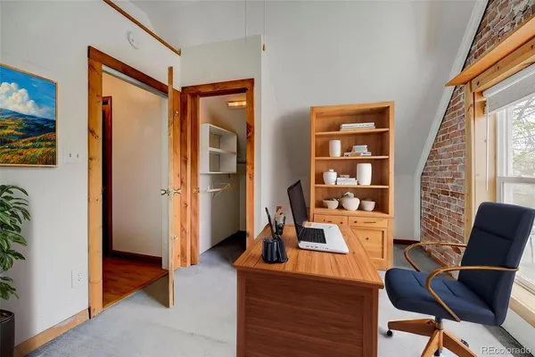 a view of a workspace with furniture and a window