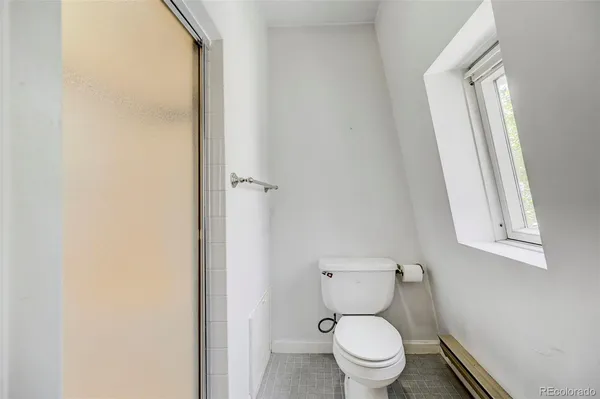 a white toilet sitting next to a window