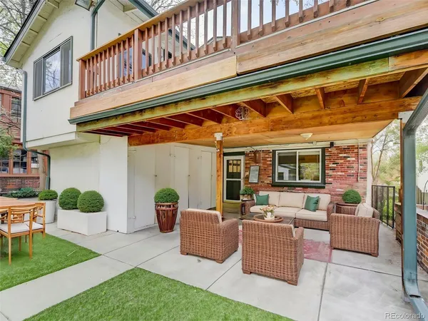 a view of a patio with couches chairs potted plants and floor to ceiling window