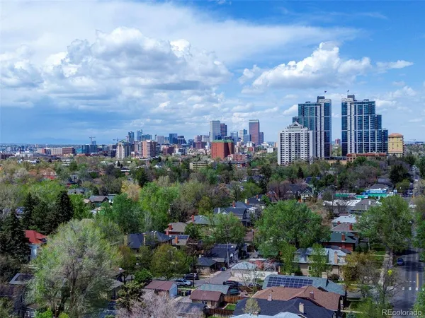 an aerial view of a city with lots of residential buildings and mountain view in back