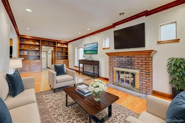 a living room with furniture a flat screen tv and a fireplace