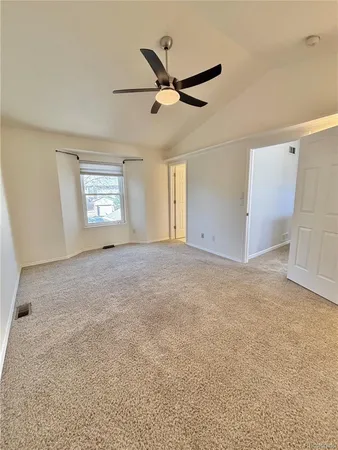 an empty room with windows and ceiling fan