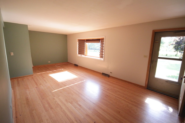 4N041 Edwards Drive Addison, IL 60101 - Photo 3 of 21 an empty room with wooden floor and windows