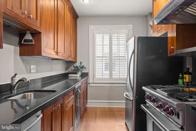 a kitchen with granite countertop a sink stove and refrigerator