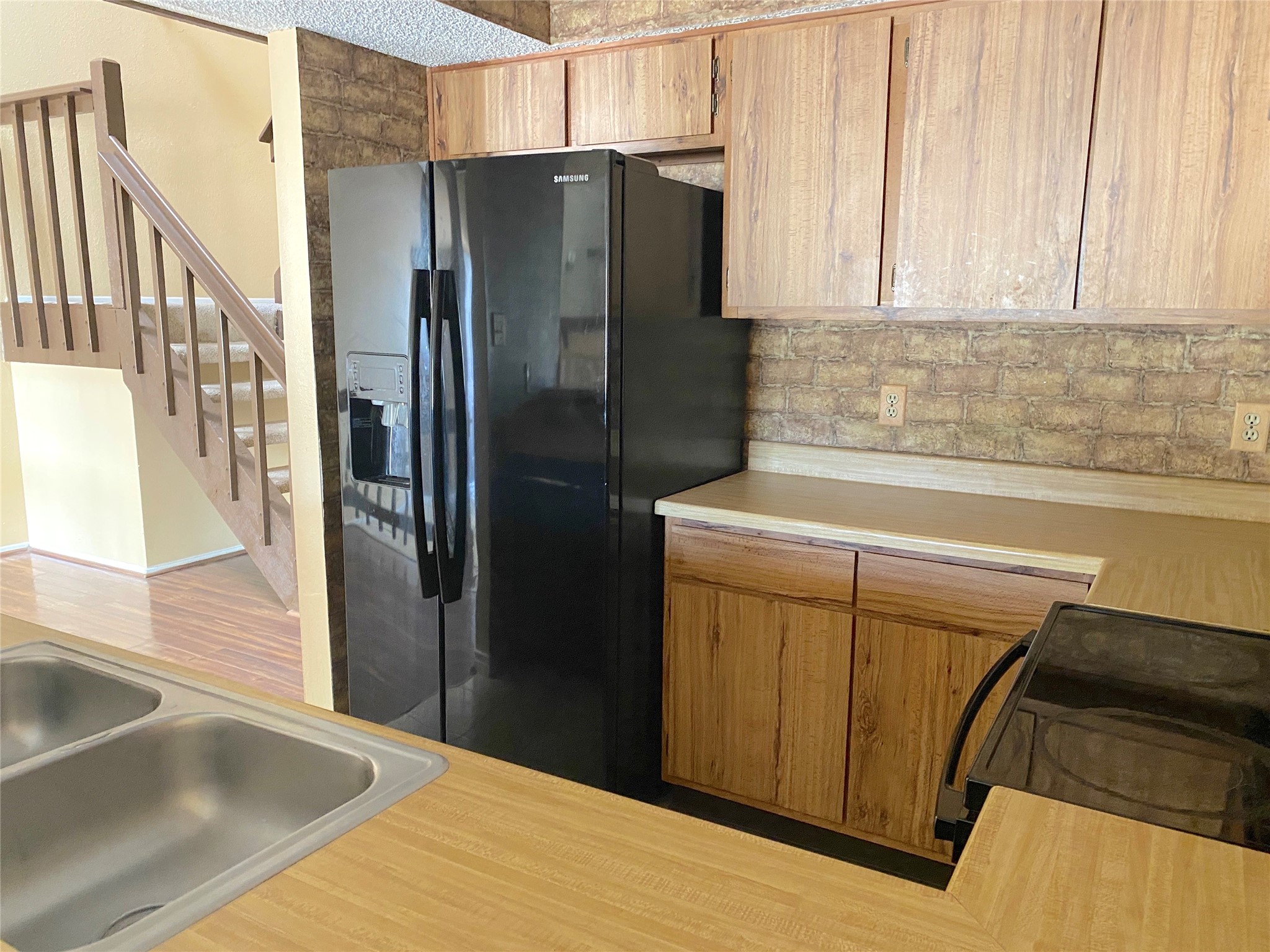 3166 Windchase Boulevard, Unit 465 Houston, TX 77082 - Photo 10 of 21 a kitchen with a refrigerator sink and cabinets