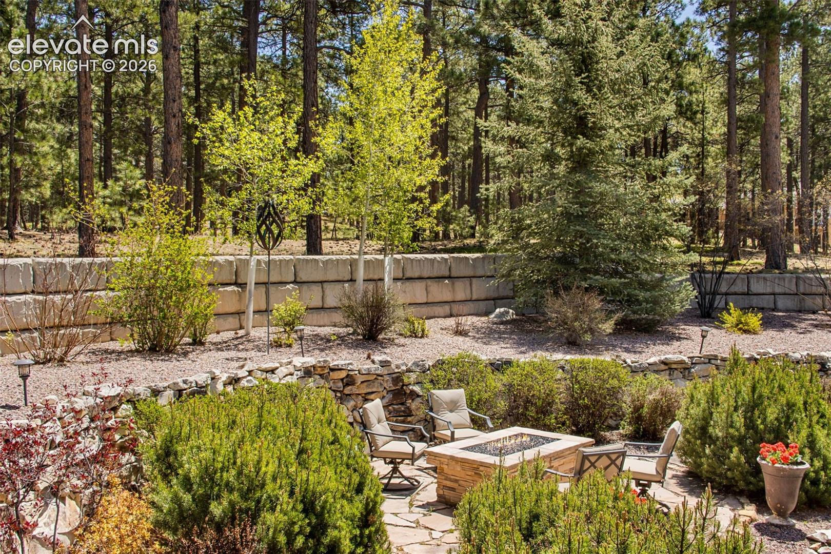 16075 Winding Trail Road Colorado Springs, CO 80908 - Photo 11 of 49 View of the backyard with the fire pit area and mature landscaping