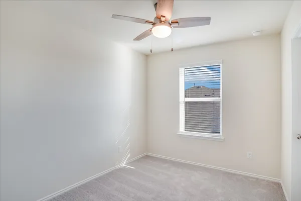 an empty room with a window and a fan