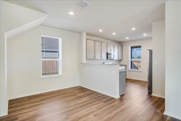 a view of a kitchen with wooden floor and a window