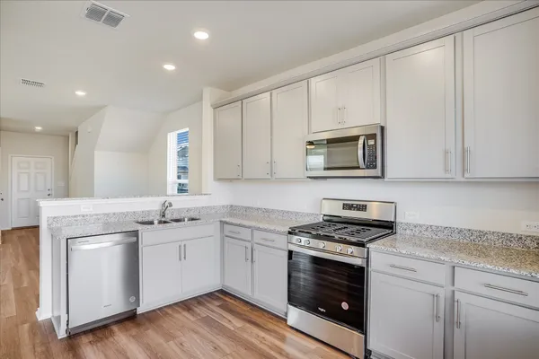 a kitchen with white cabinets stainless steel appliances and sink