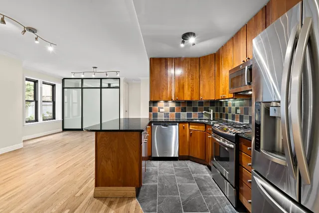 a kitchen with stainless steel appliances granite countertop a refrigerator and a stove