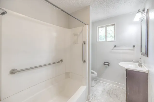 a bathroom with a sink a toilet and shower