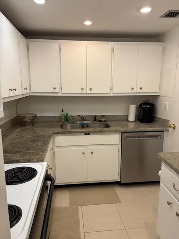 a kitchen with granite countertop white cabinets and white appliances