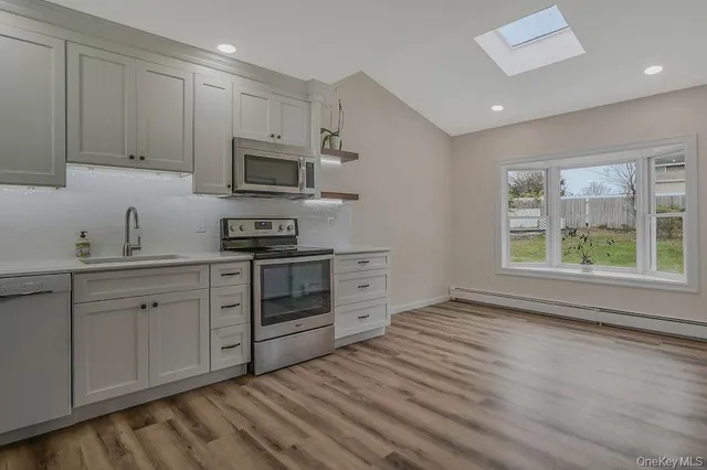 a kitchen with stainless steel appliances granite countertop a stove a sink and a microwave