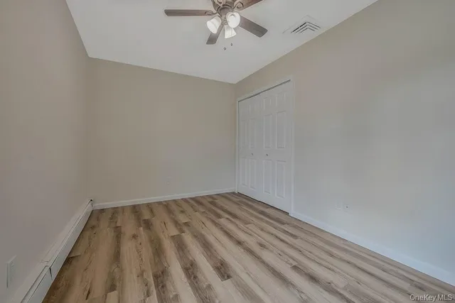 a view of room with hardwood floor and ceiling fan
