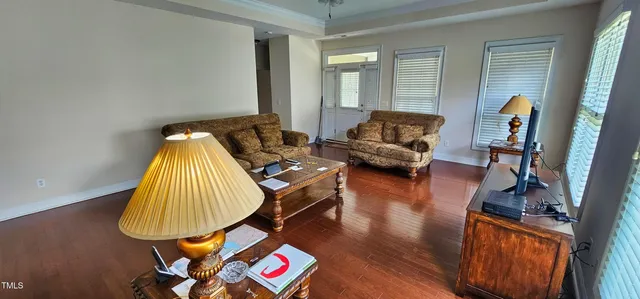 a living room with furniture and a wooden floor