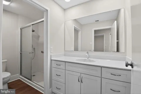 a bathroom with a granite countertop sink mirror and toilet