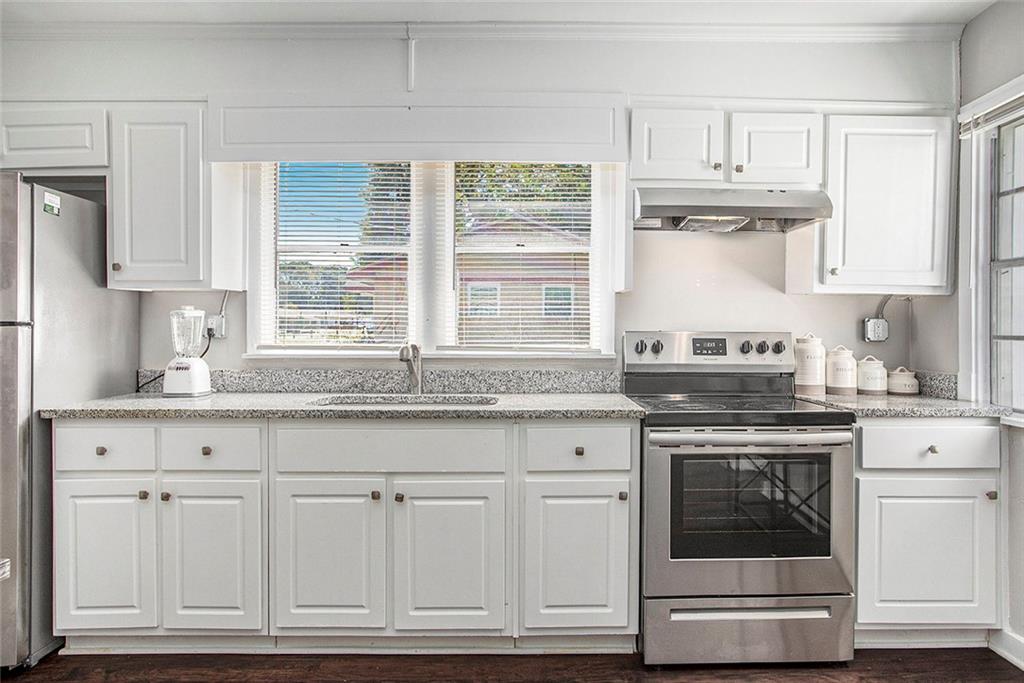 1298 Irwin Bridge Road Northwest Conyers, GA 30012 - Photo 9 of 25 a kitchen with granite countertop white cabinets and white stainless steel appliances