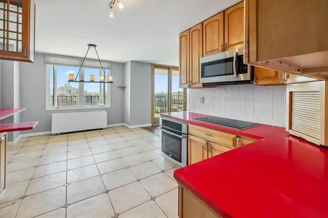 a kitchen with stainless steel appliances granite countertop a stove a microwave and a refrigerator