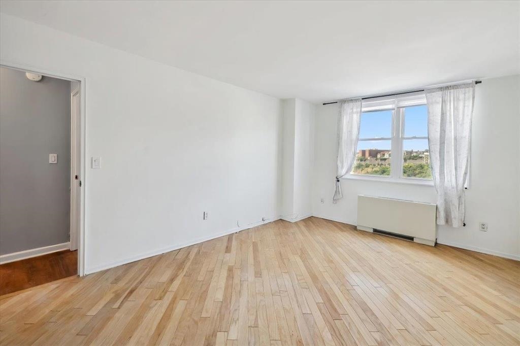 380 Mountain Road, Unit 213 Union City, NJ 07087 - Photo 14 of 24 an empty room with wooden floor and windows