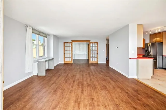 a view of a kitchen with wooden floor and a window