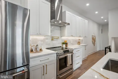 a kitchen with stainless steel appliances a stove a refrigerator and cabinets