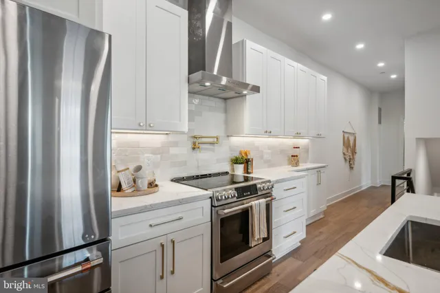 a kitchen with stainless steel appliances a stove a refrigerator and cabinets