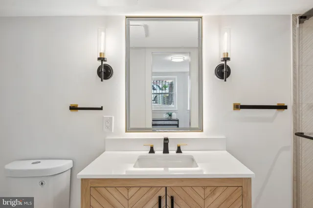 a bathroom with a sink toilet and mirror