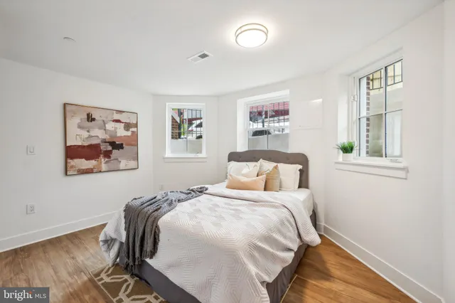 a bedroom with a bed and a painting on the wall