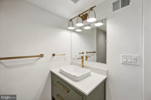 a bathroom with a sink a light fixture and a mirror