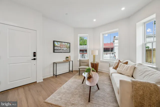 a living room with furniture and a wooden floor