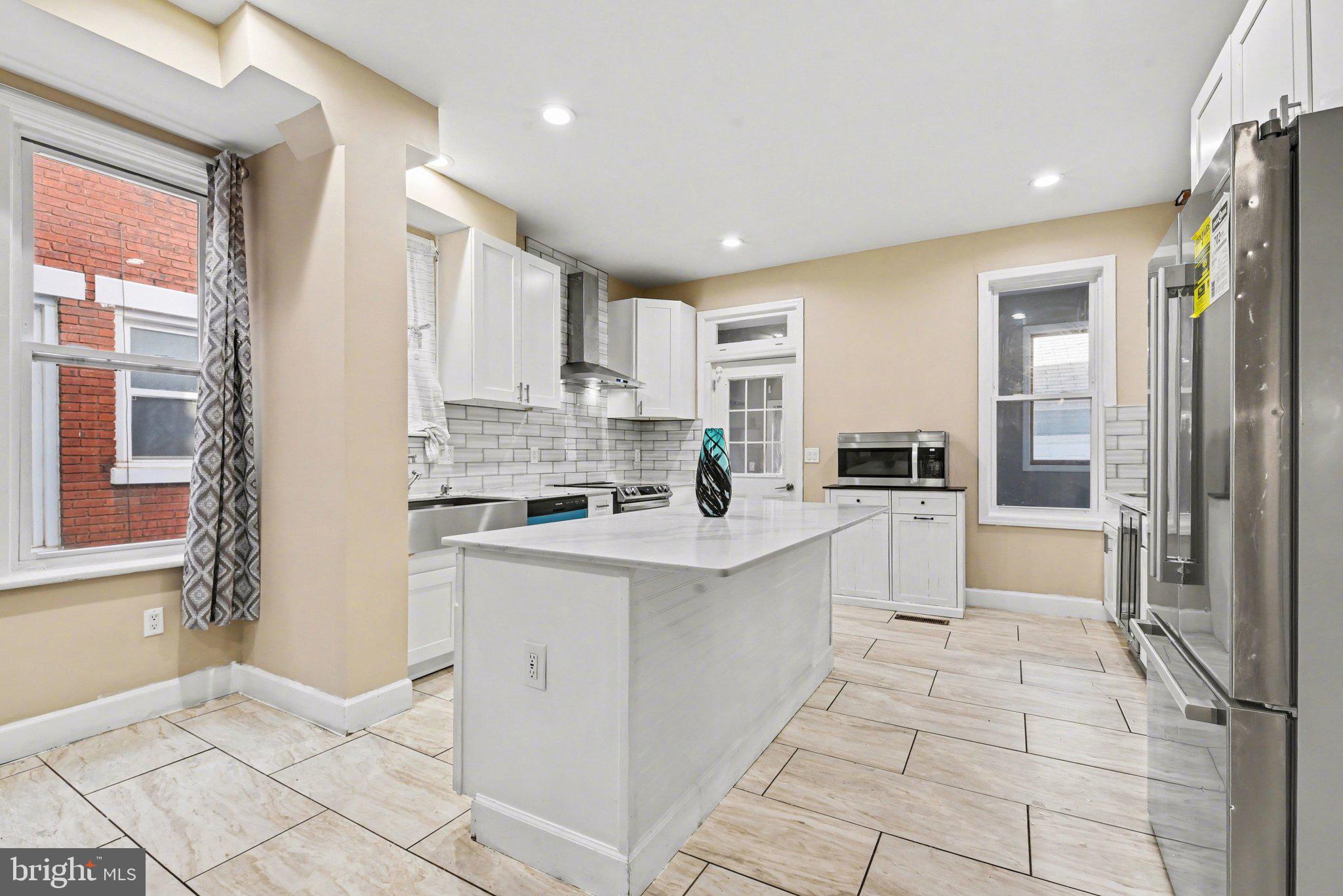 918 North 16th Street Harrisburg, PA 17103 - Photo 7 of 31 a kitchen with white cabinets and white appliances