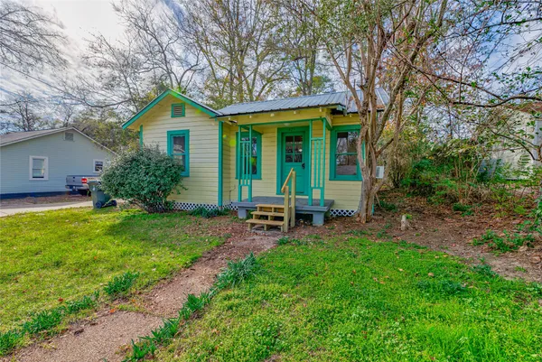 a view of a house with a yard and sitting area