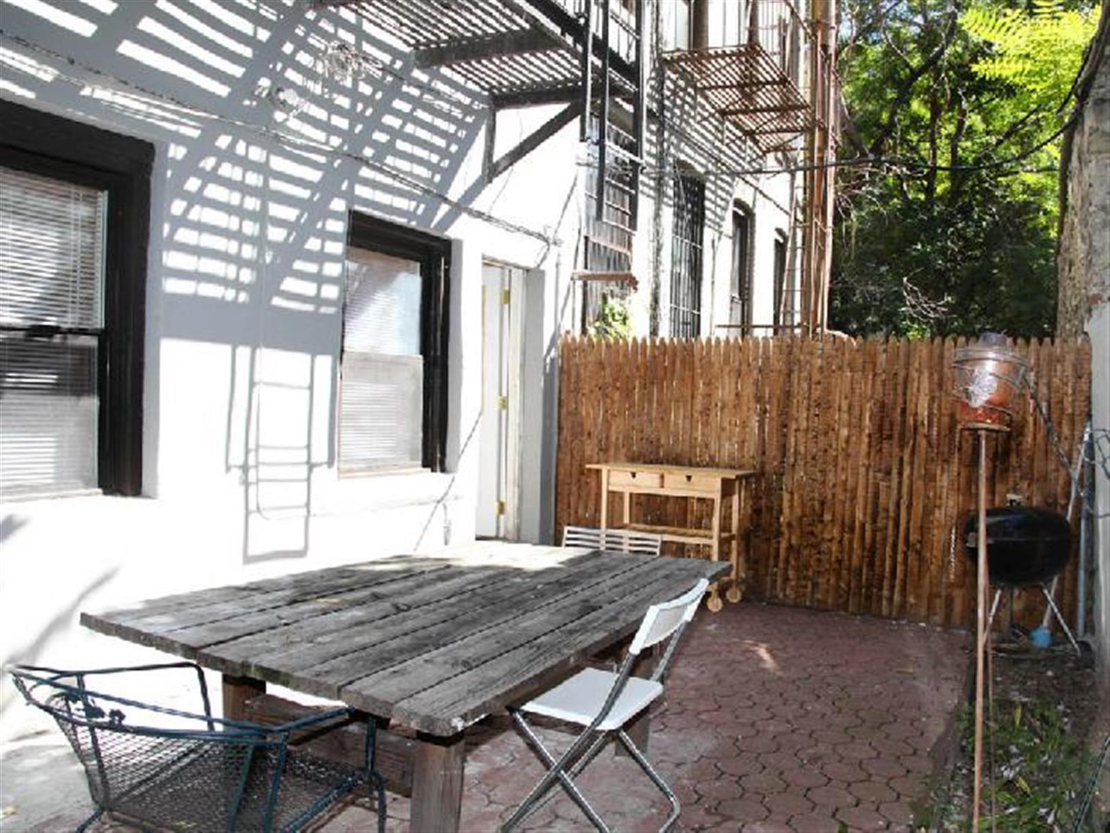 a backyard of a house with table and chairs