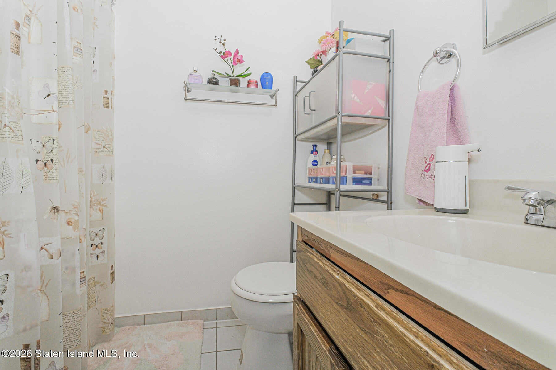 212 Ilyssa Way Staten Island, NY 10312 - Photo 17 of 21 a bathroom with a sink a toilet and shower curtain
