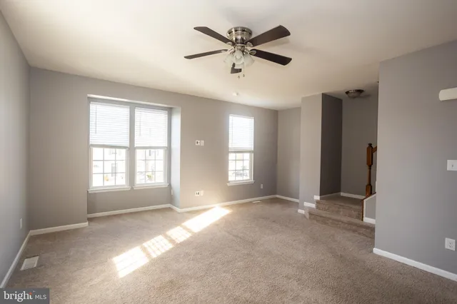 a view of a livingroom with a ceiling fan and window