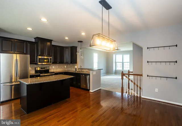 a kitchen with granite countertop a refrigerator stove and sink