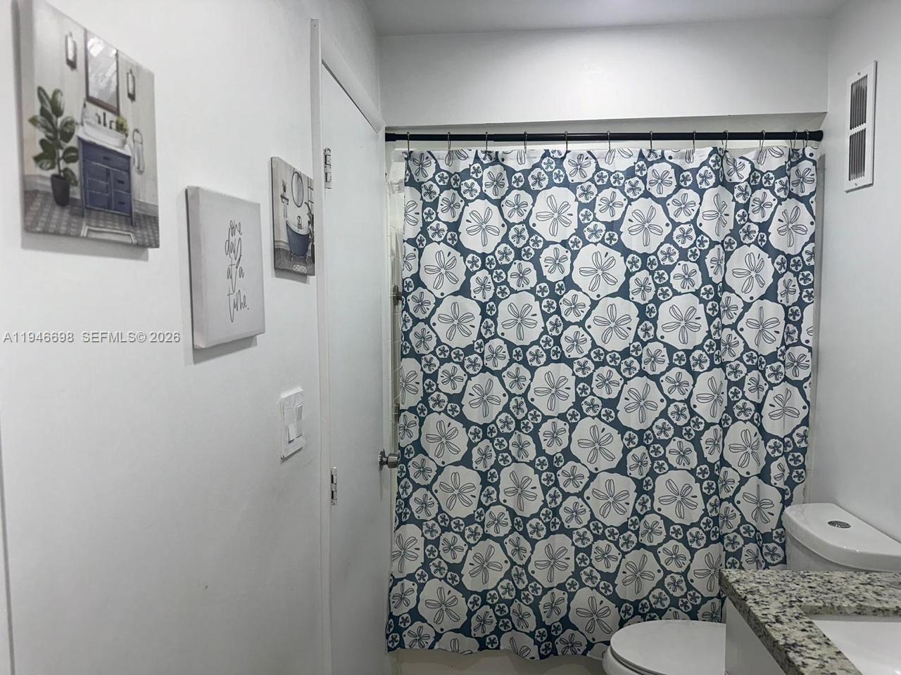 15560 Southwest 104th Terrace, Unit 6112 Miami, FL 33196 - Photo 12 of 12 a white toilet sitting next to a shower curtain